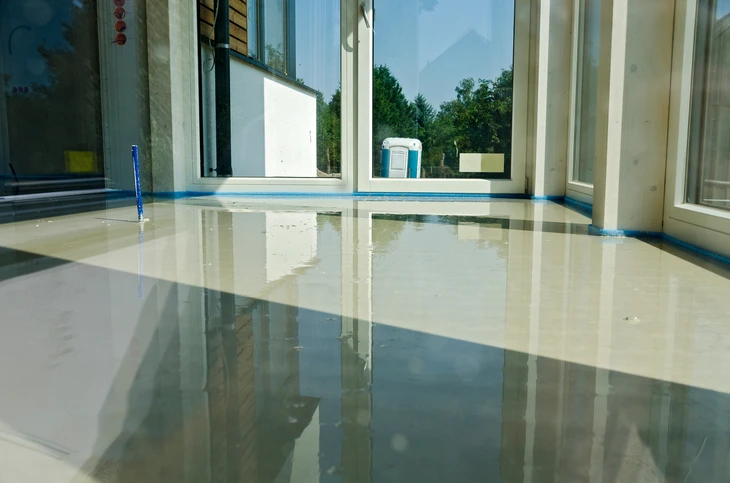 Intérieur de bâtiment en construction avec sol inondé d'eau stagnante