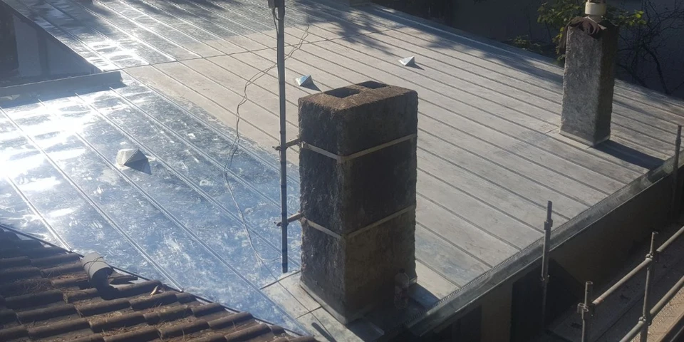 Scène extérieure montrant une flotte de fourgonnettes utilitaires blanches stationnées en rangée devant un bâtiment moderne à bardage bois