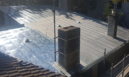 Maison résidentielle moderne avec façade mixte pierre naturelle beige et bardage vinyl gris