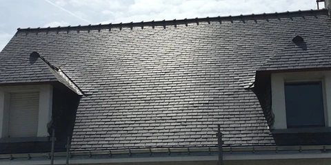Maison contemporaine unifamiliale avec façade mixte en bardage bois et ardoise grise, toiture plate zinc