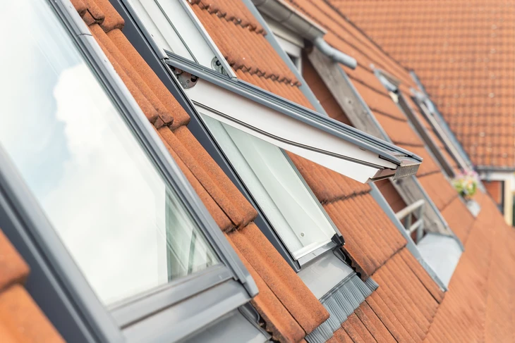 Ventilation ouverte de l'extérieur de la fenêtre du toit imperméable contre la lumière du ciel ensoleillée
