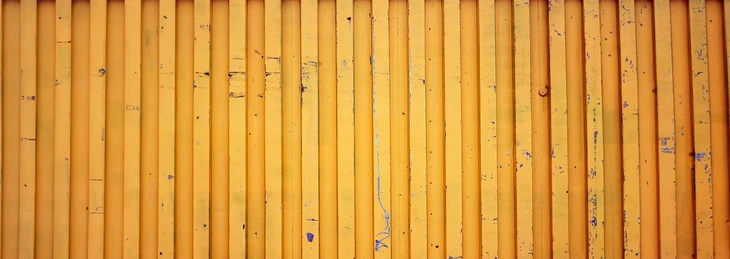 Façade extérieure d'un bâtiment industriel ou commercial avec bardage métallique ondulé de couleur jaune orangé