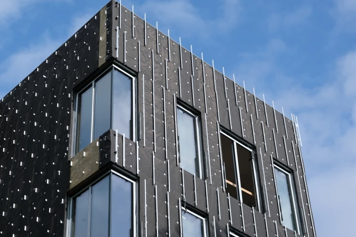 Isolation avec structure imperméable au vent d'une façade en noir sur un ciel bleu
