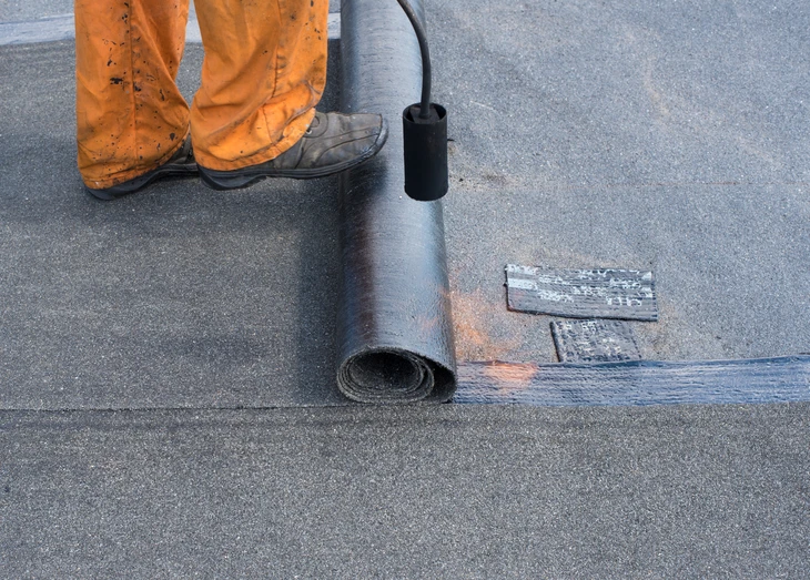 Scène extérieure de travaux d'étanchéité sur toiture plate