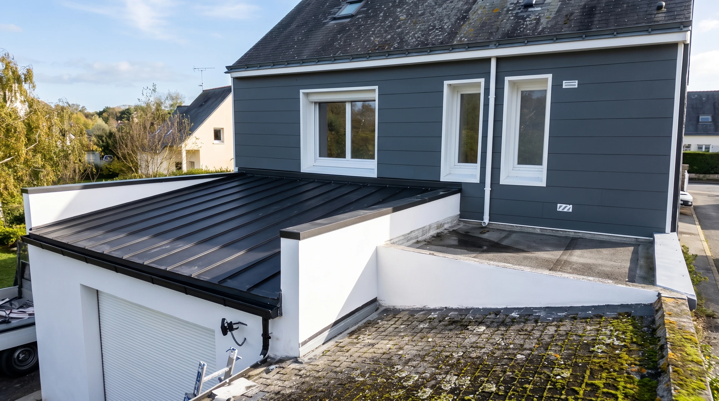 Un homme en chemise à carreaux et casquette installe une terrasse extérieure, agenouillé sur une structure en cours de construction